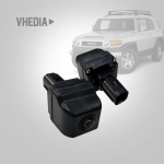 FJ Cruiser_Camera Upgrade - VHEDIA Close-up of a black backup camera module for a vehicle, with a blurred SUV in the background to suggest installation context.