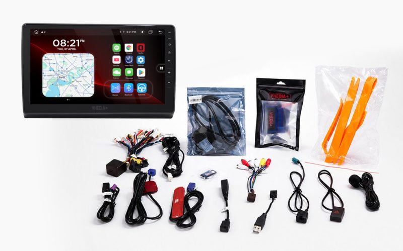 Car infotainment head unit with many installation cables and accessories on a white background.